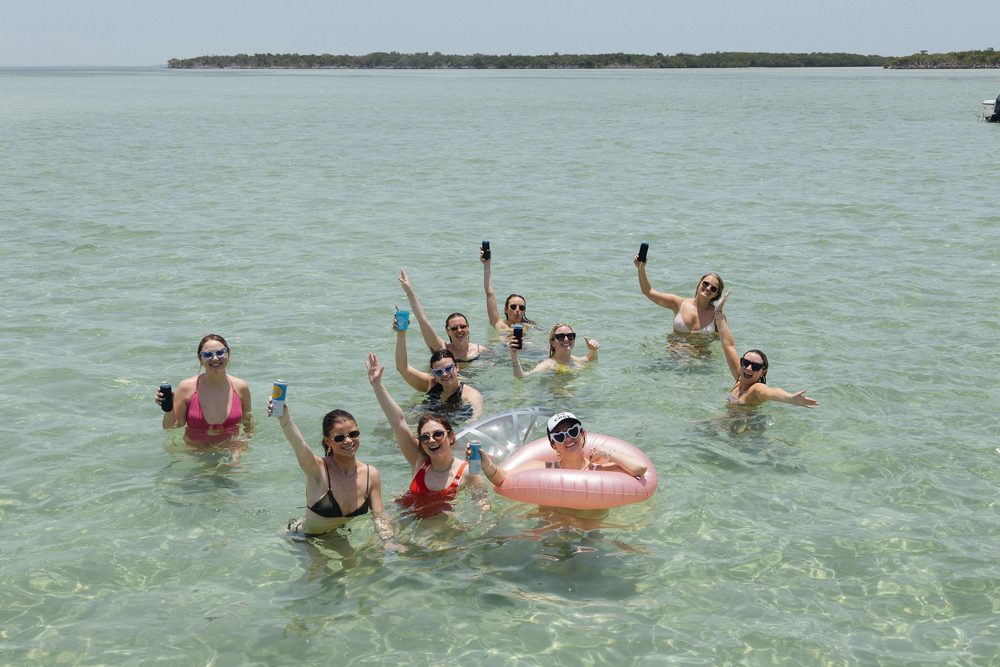 A big group standing in the clear water at Snipes Key
