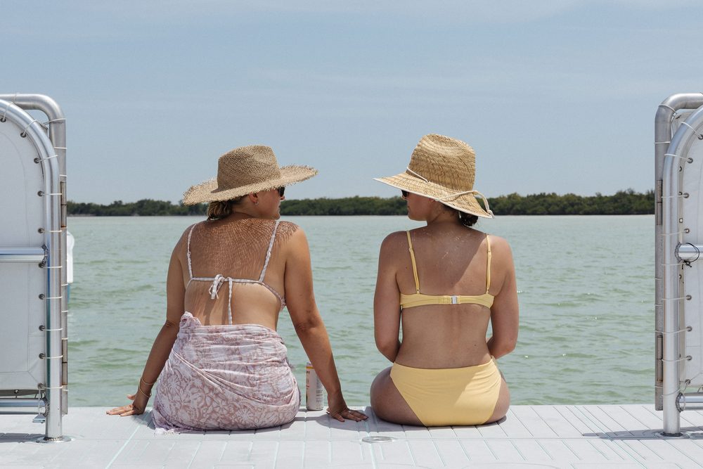 Two guests in straw hats sitting on the bow