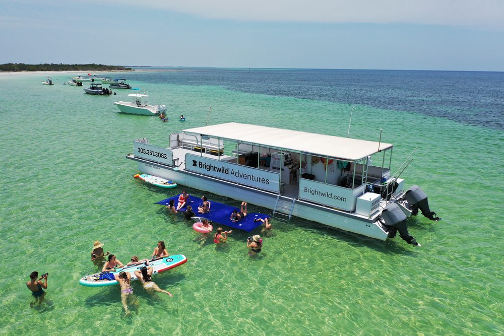 Aerial view of the Brightwild boat at the sandbar with guests on paddleboards, floats and the lily pad mat