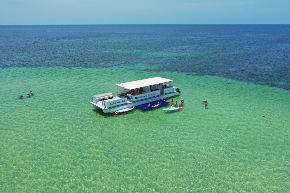 Aerial view of the Brightwild boat anchored over turquoise water