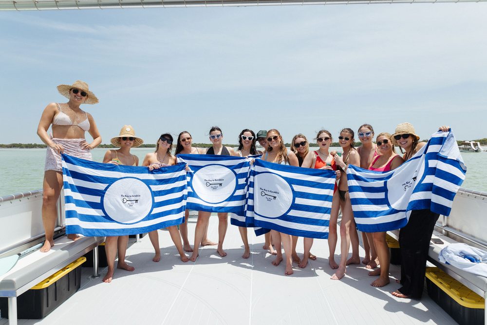 A bachelorette group holding a banner
