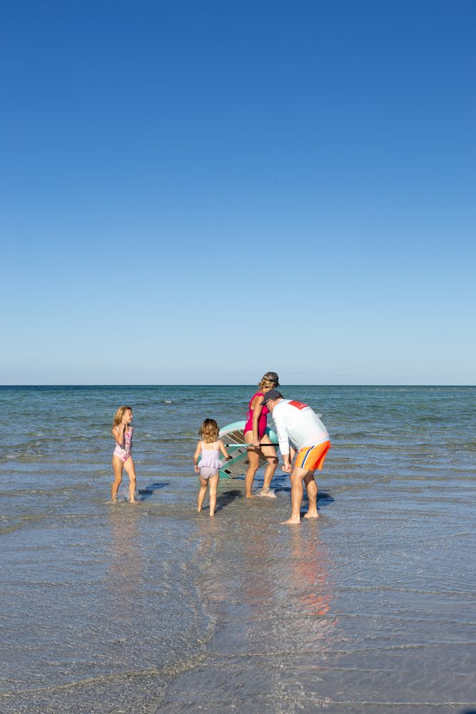 Parents and kids in the shallow water