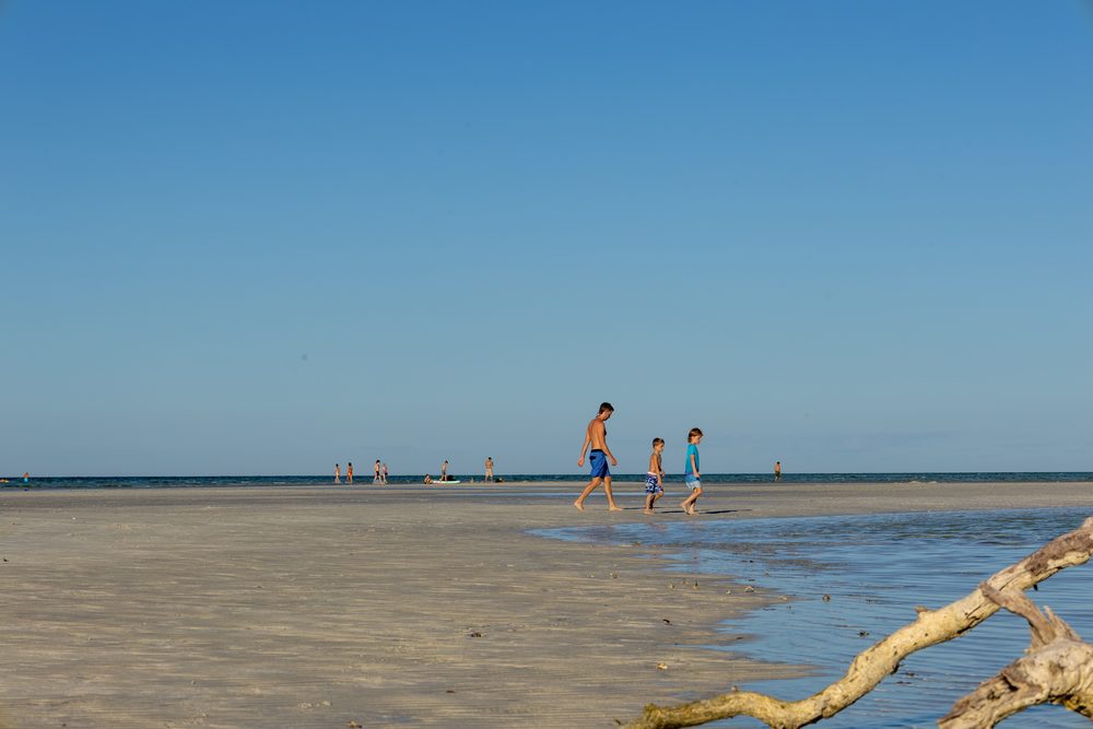 Guests walking the sandbar at low tide
