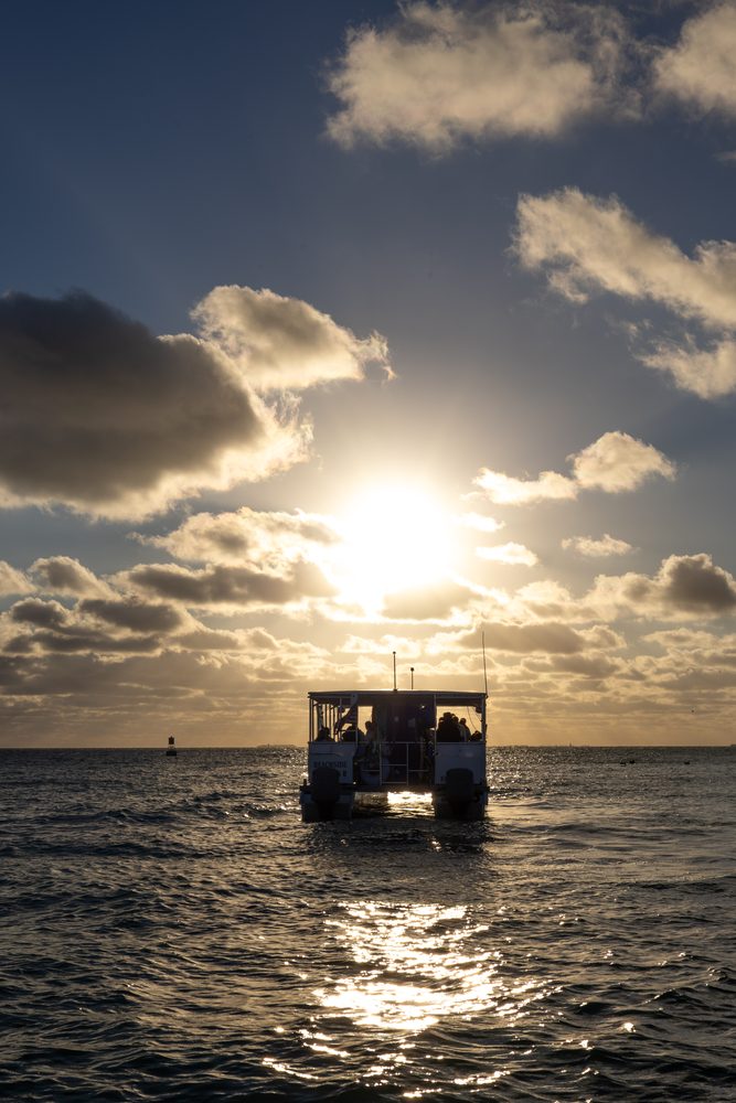 The boat silhouetted against the setting sun