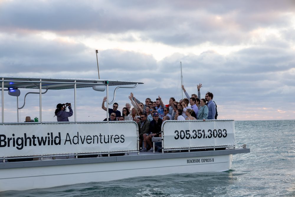 Guests waving from the boat at sunset