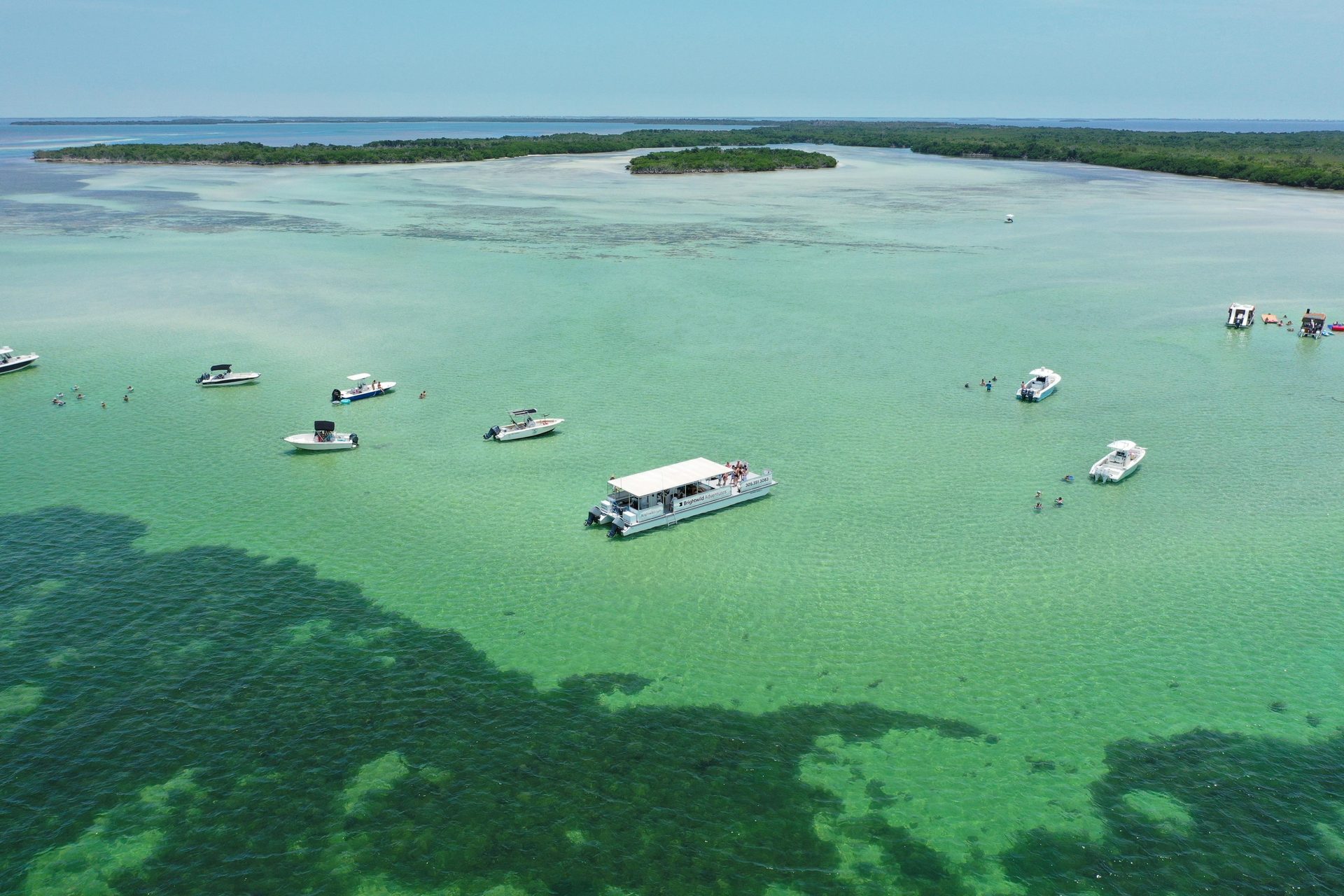 Aerial view of a Key West sandbar with boats anchored near a mangrove island
