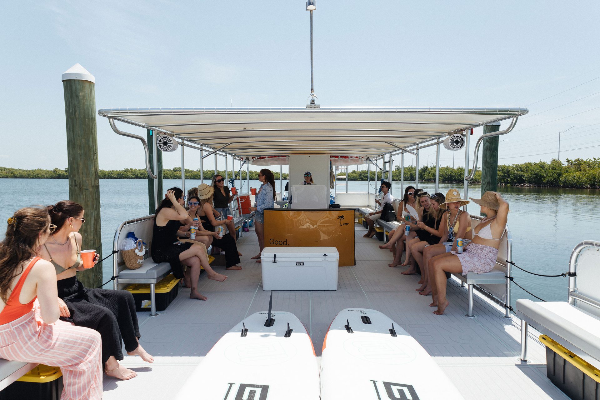 Guests seated on the cushioned benches under the canopy