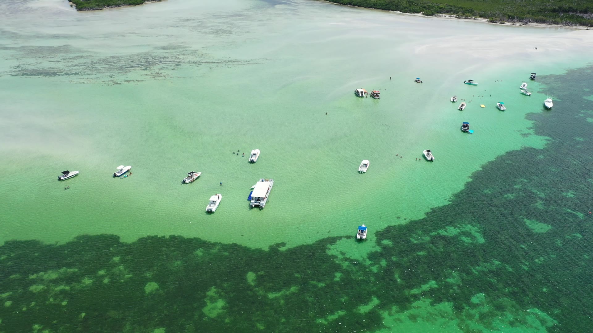 Wide aerial of the Key West sandbar with boats anchored along its edge